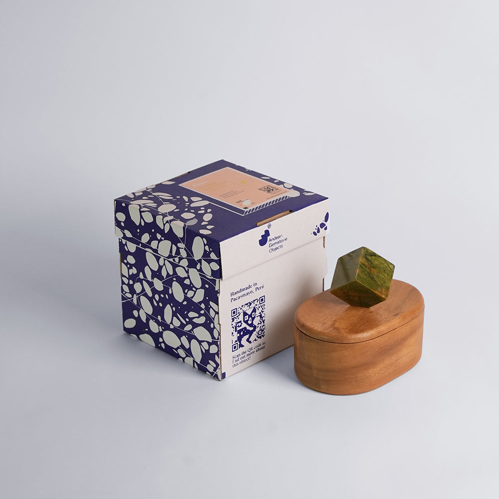 Oval jewel box with green serpentine knob beside its patterned gift carton