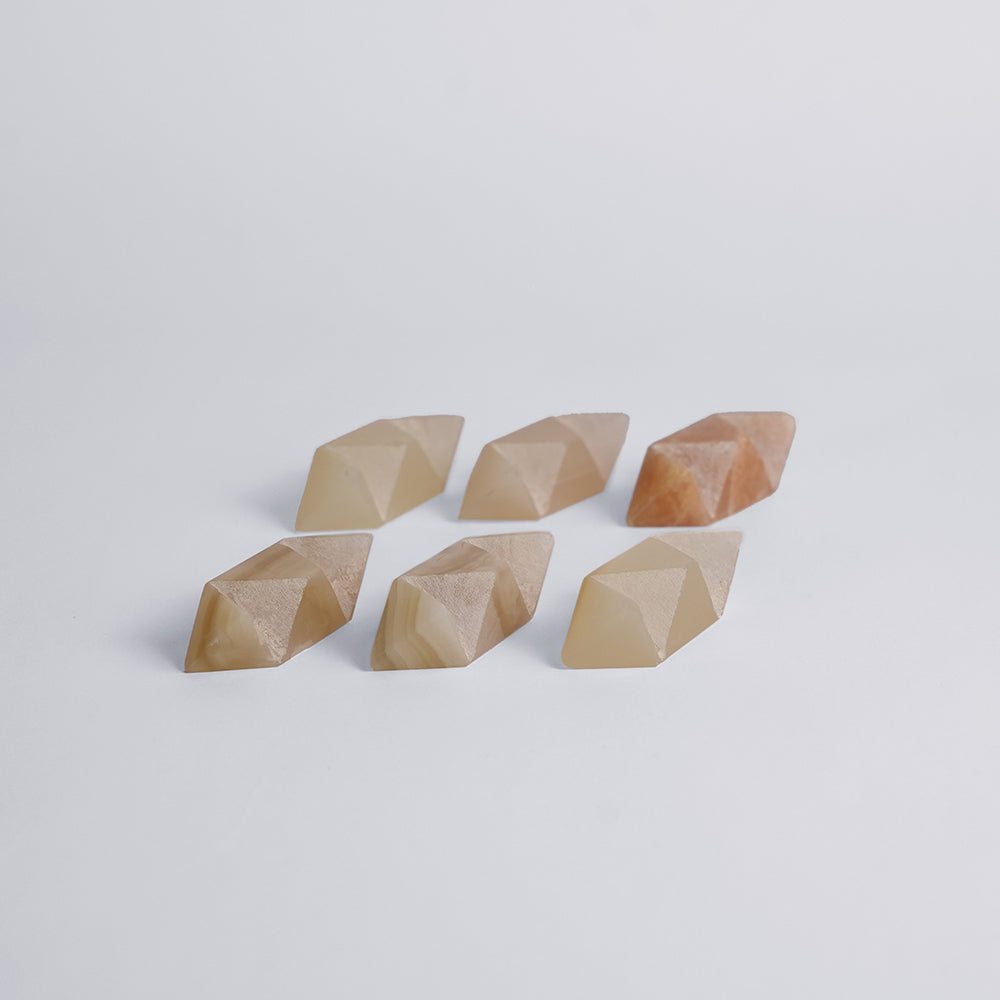 The six hand-cut stone pieces of the burr star puzzle laid out separately