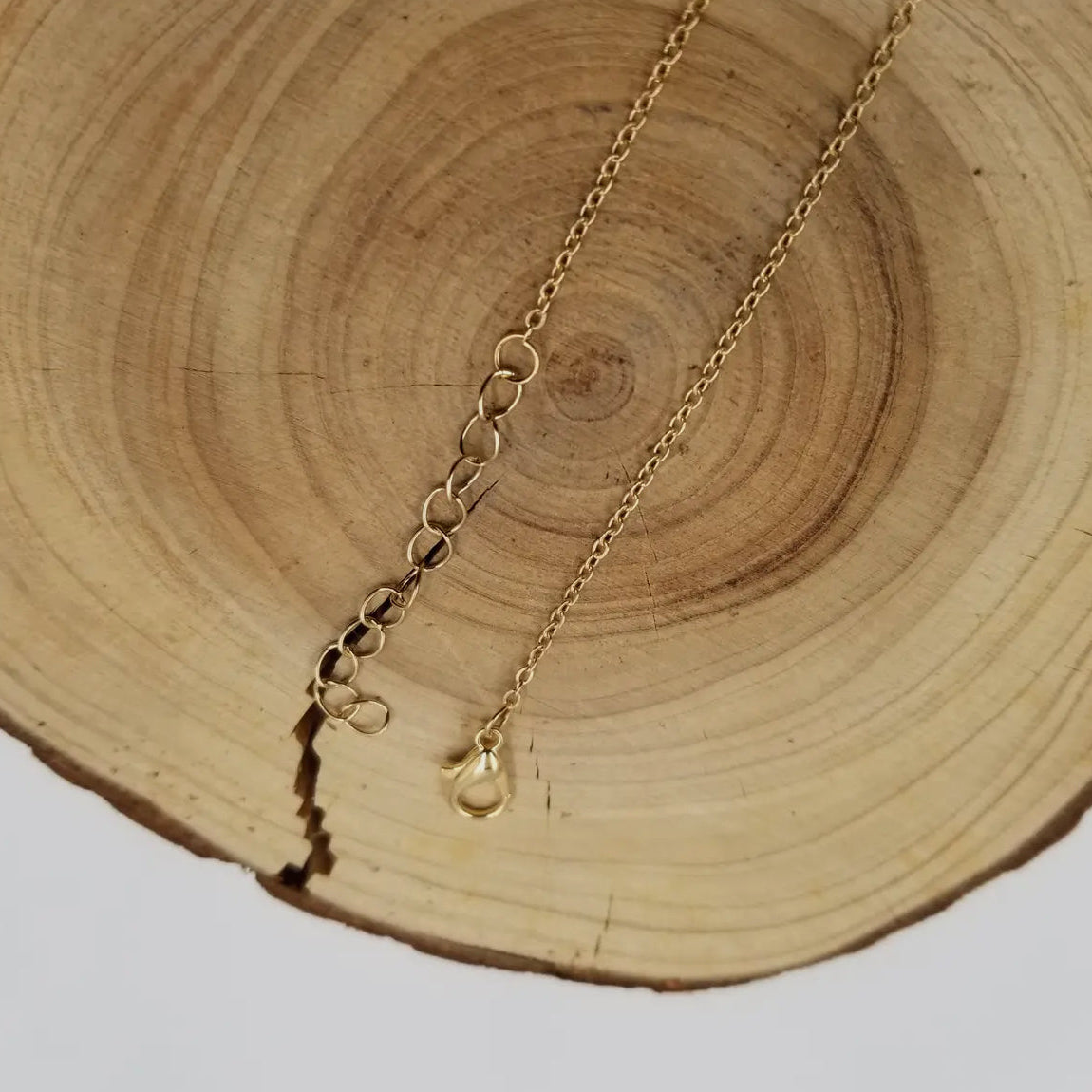 The wire-wrapped green fluorite necklace laid flat to show the stone's organic edges.