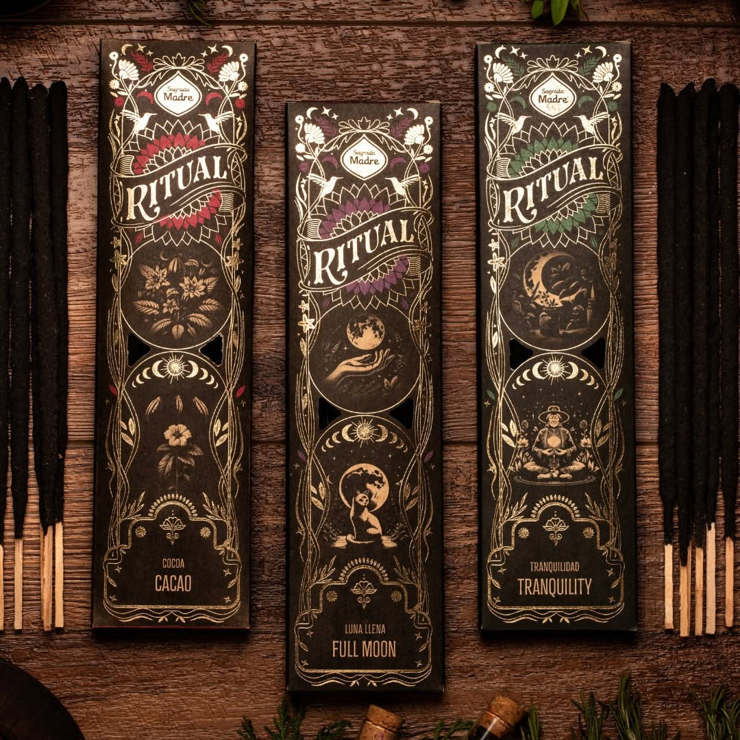 Three Ritual incense packs on wood, labeled Cacao, Full Moon and Tranquility, with loose sticks alongside