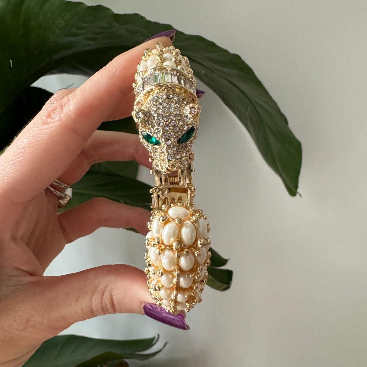 Head-on view of the pearl panther cuff, the pavé face above the pearl-set tail.