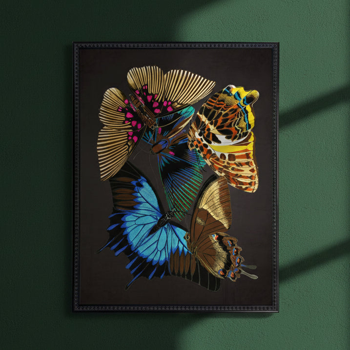 Framed butterfly print with a leopard motif on a dark ground, in a black beaded frame on a green wall