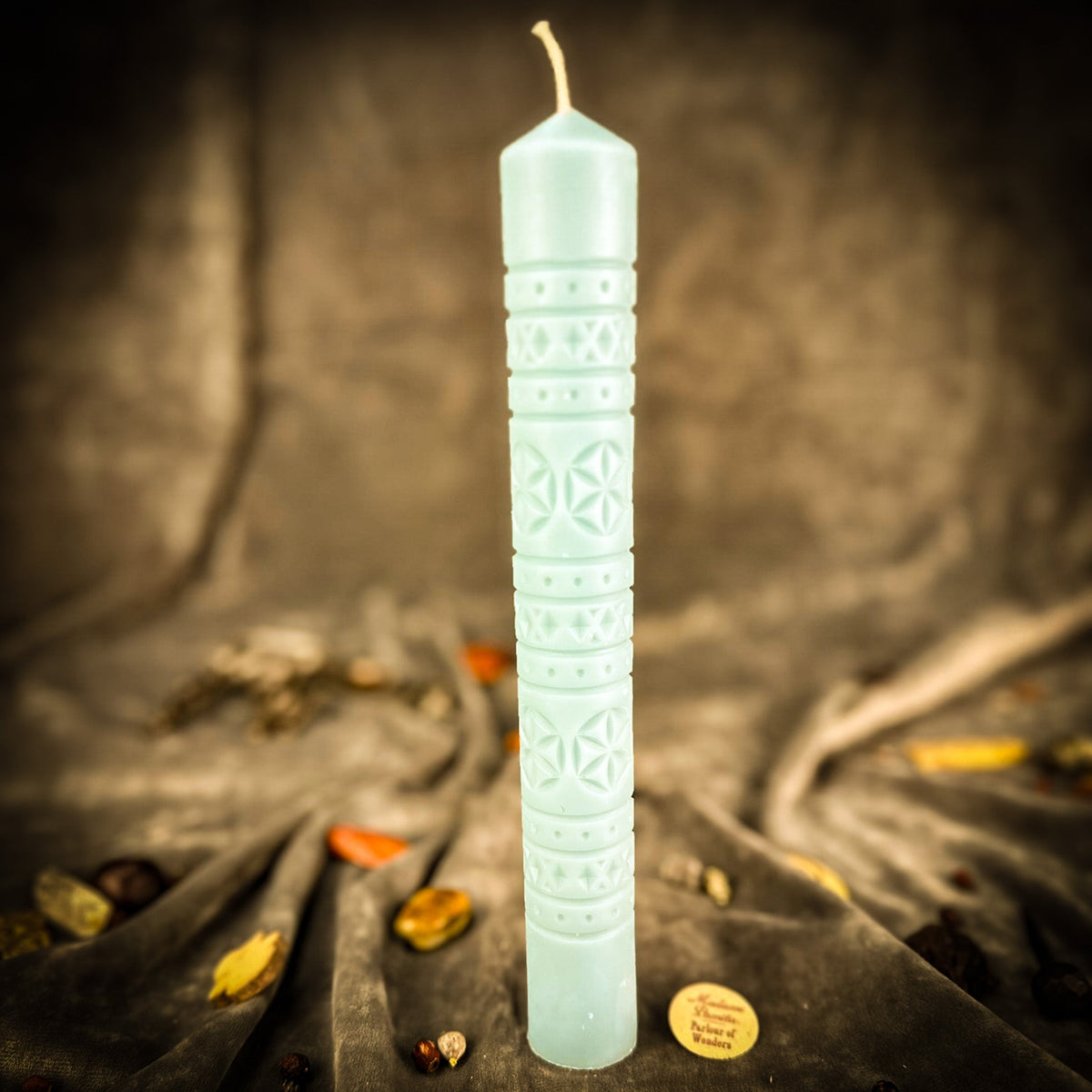 Rozetka rosette beeswax pillar candle in pale blue on draped fabric