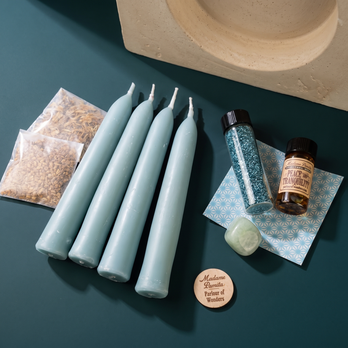 Tranquility Candle Spell Booster Pack with four blue beeswax taper candles, Peace and Tranquility oil, herbs, a tumbled gemstone and glass glitter