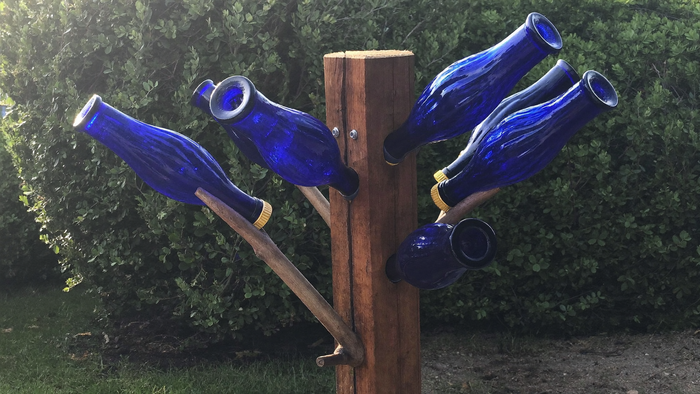 Bottle tree: cobalt blue glass bottles on the branches of a wooden post in a Southern garden