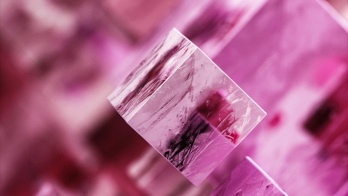 Close-up of translucent pink rose quartz crystal faces catching soft light
