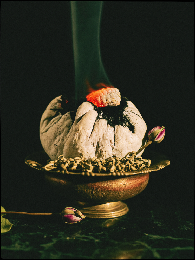 Smoldering white sage bundle in an antique brass bowl