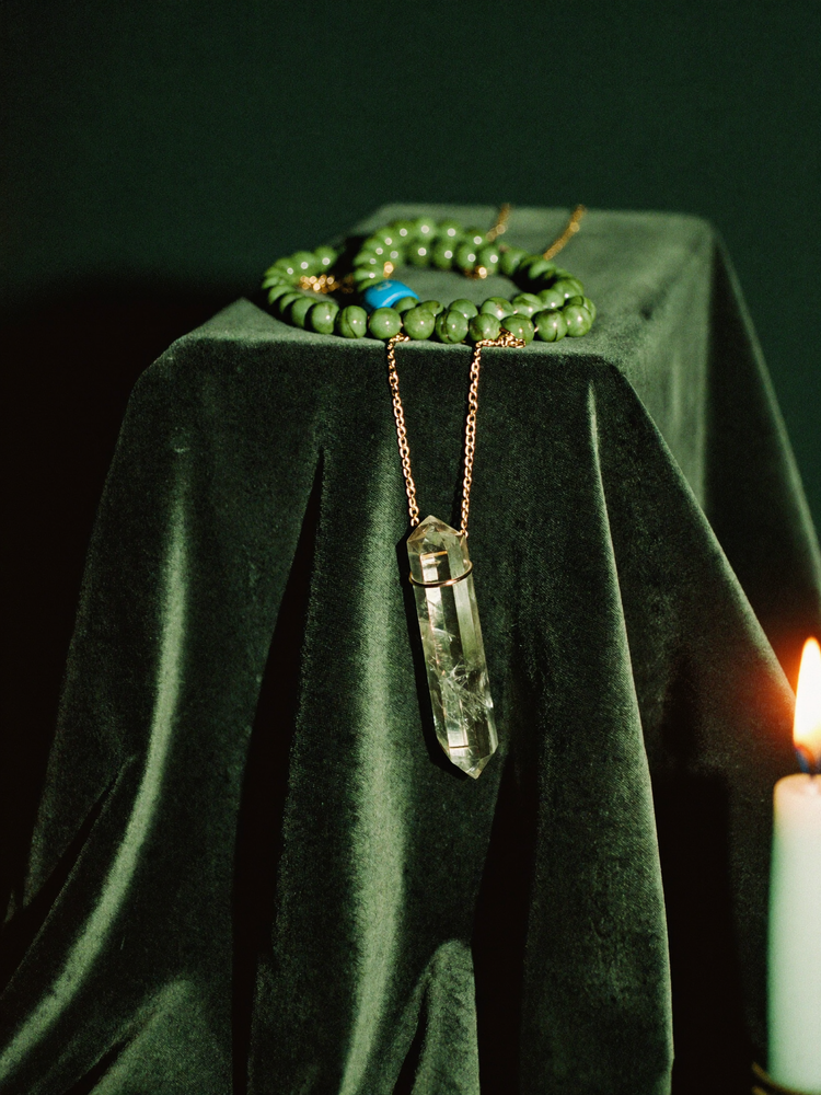 Crystal pendant and fluorite necklace in candlelight
