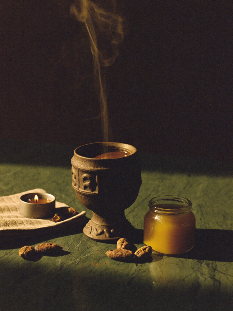 Ceremonial cacao in a clay cup with ghee and linen