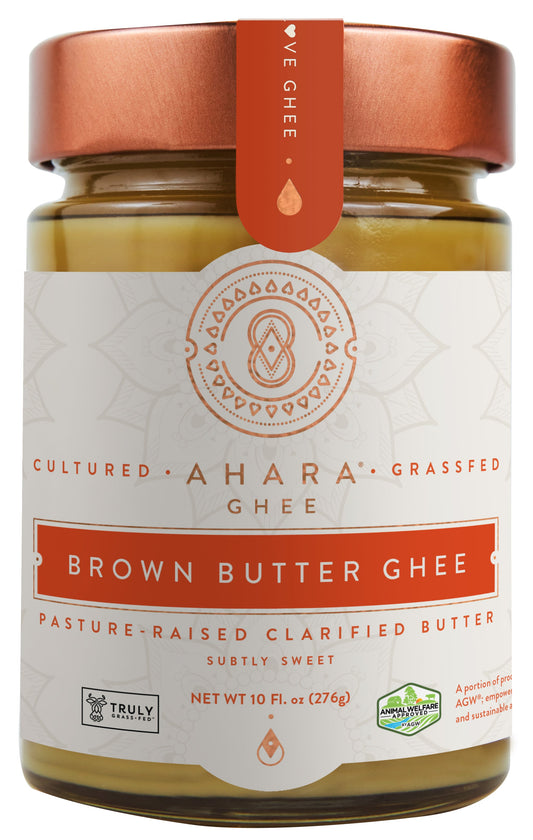 A glass jar of Ahara Rasa Brown Butter grass-fed ghee with a copper lid and orange label band.