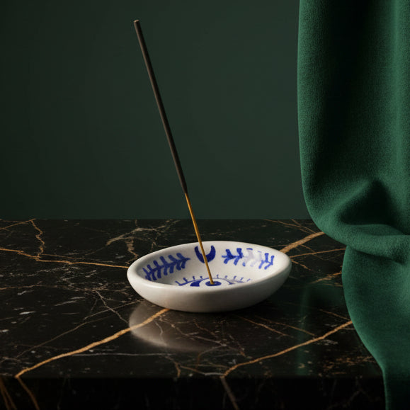 Lalita evil eye ceramic incense dish on black marble, incense stick burning