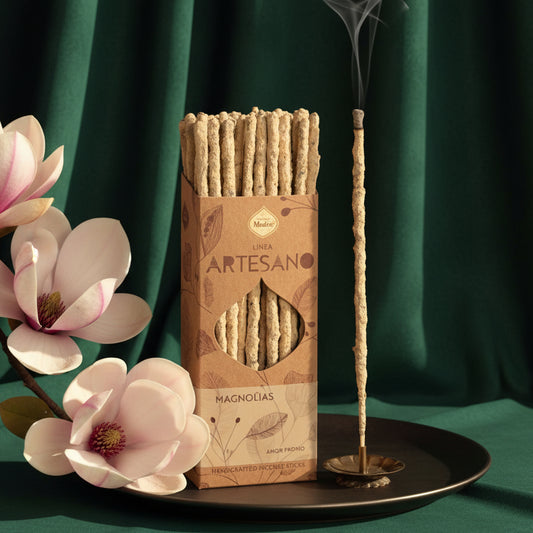 Magnolia incense sticks standing in a vase beside the Artesano box and a magnolia flower