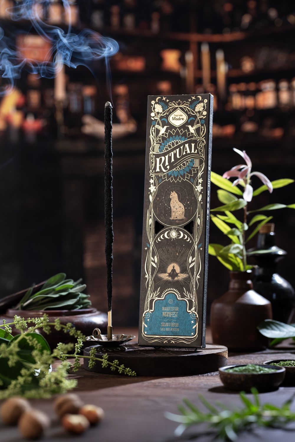 Manifest Ritual incense box smoking in a dark room with fresh herbs around it
