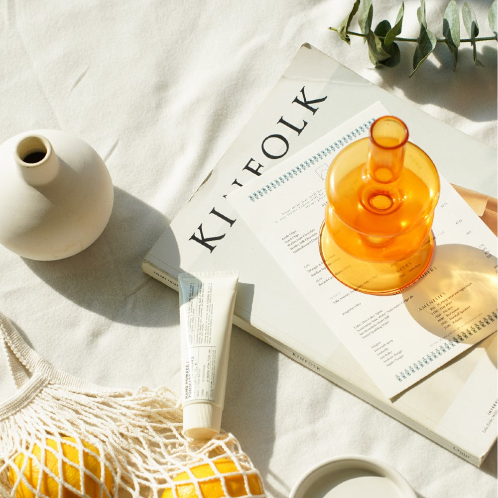 Amber Gigi glass holder styled on linen beside a magazine and a small vase