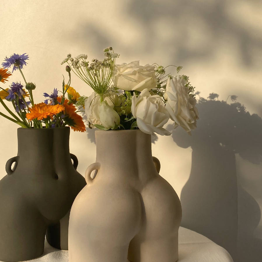 Two Her Vases filled with wildflowers and white roses in daylight