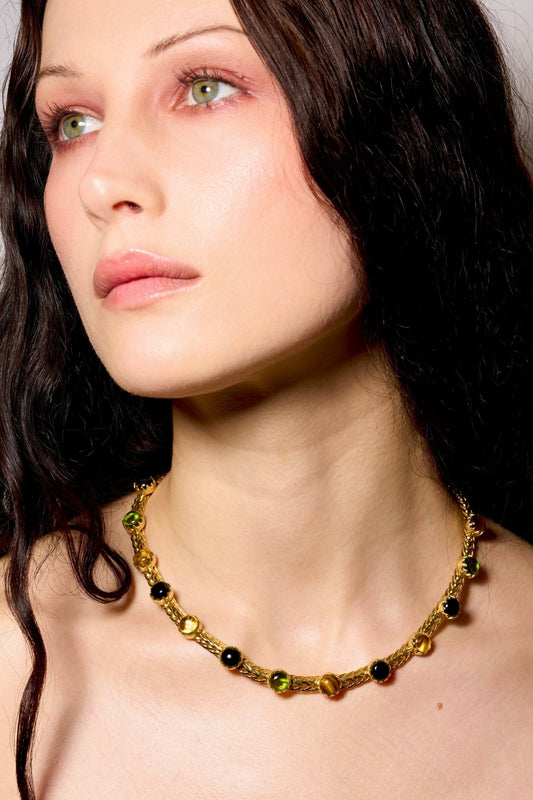 A woven gold chainmail choker set with genuine black onyx, tiger eye and peridot stones.