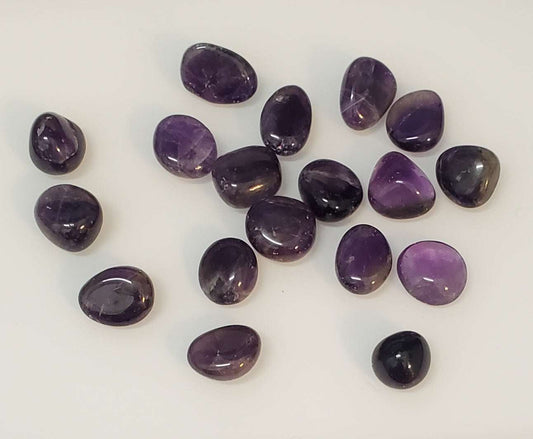 Small tumbled purple amethyst pocket stone with a polished surface