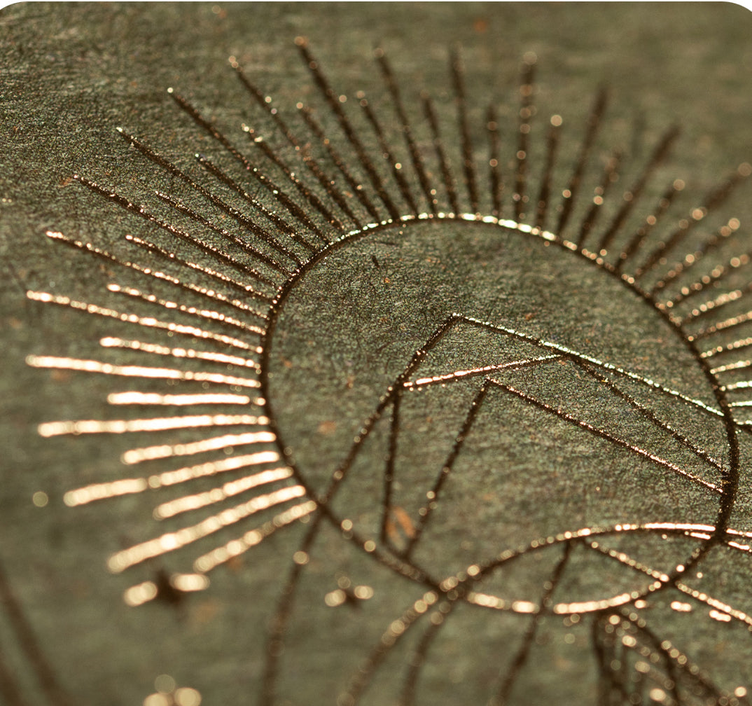 Gold sunburst detail embossed on the olive-green Kundalini box