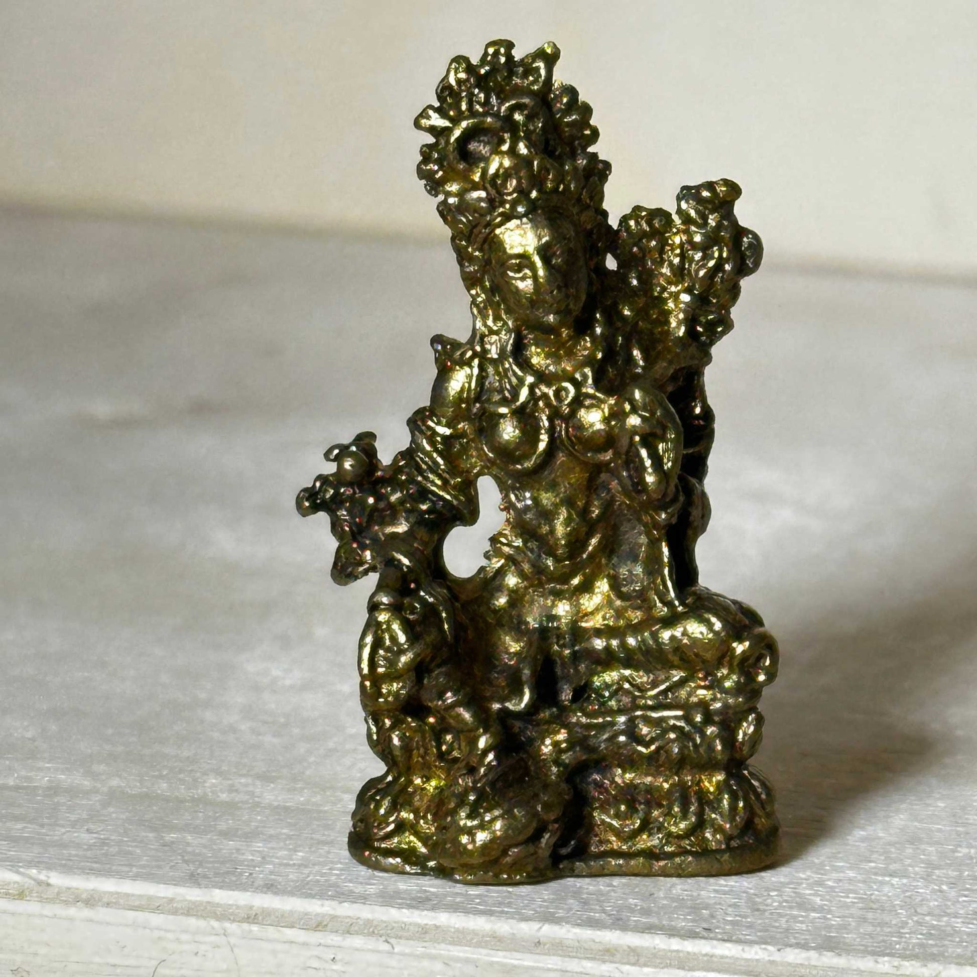 Small brass statue figurine sized to fit in the palm of a hand, detail of the finish