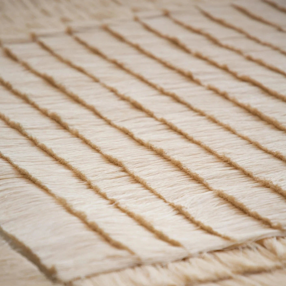 Close detail of the tapestry's horizontal cotton rows and raw fringed edge