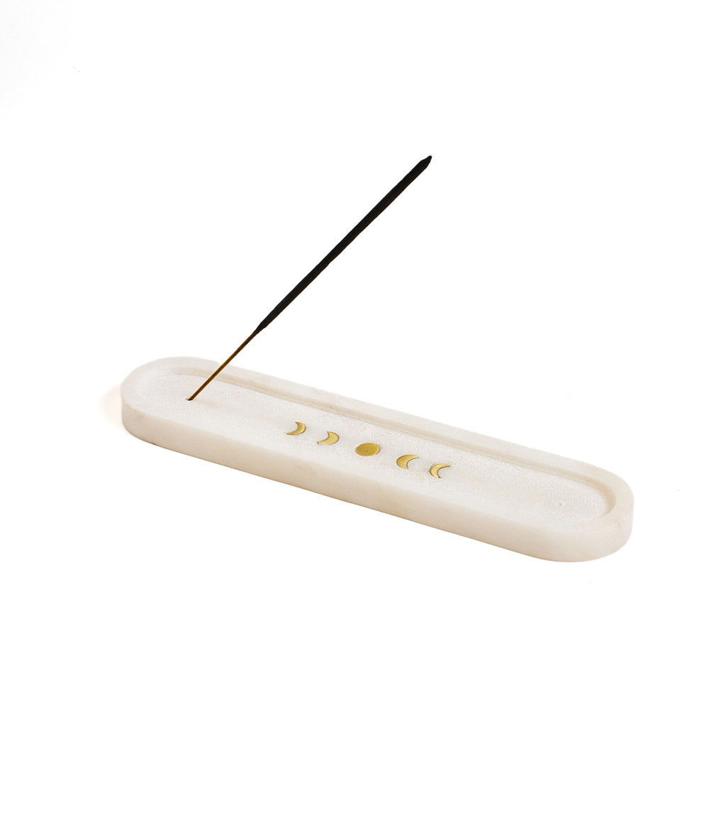 Marble incense holder with brass lunar phases and a single stick set upright