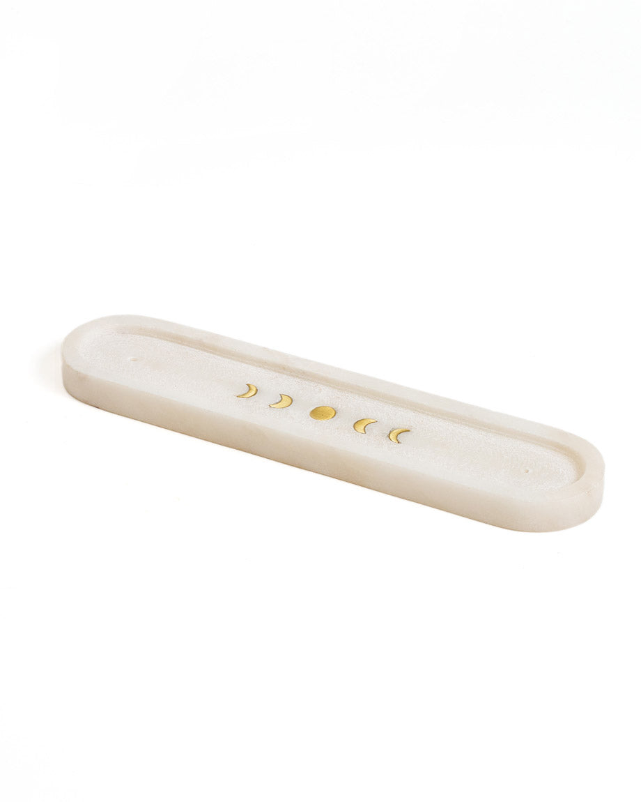 White marble moon phase incense tray with five brass lunar symbols along the well