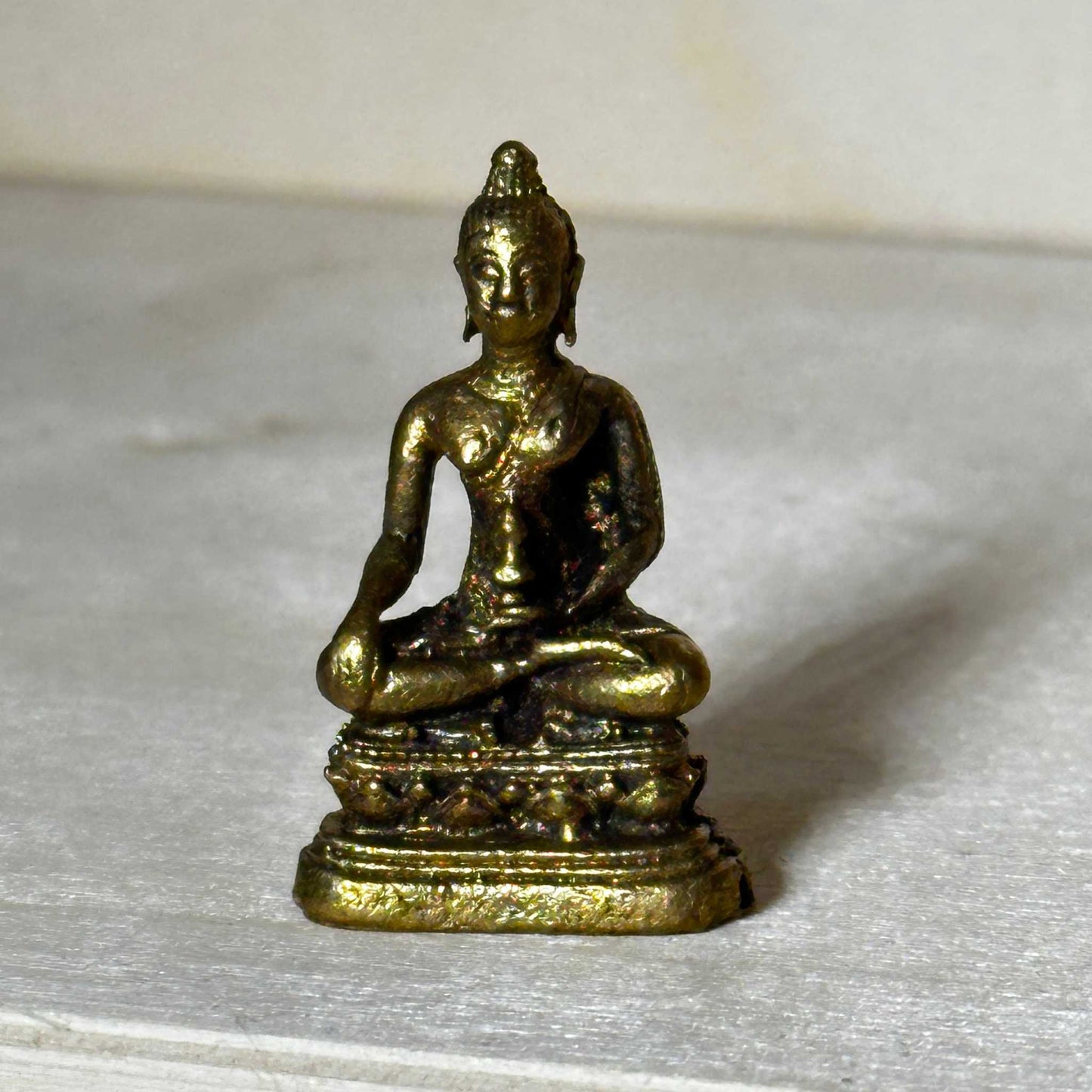 Small brass statue figurine sized to fit in the palm of a hand, alternate view