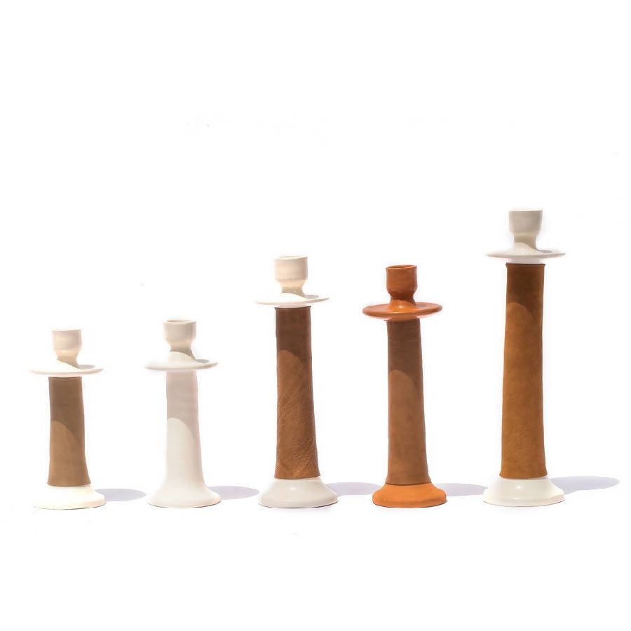 Five leather-wrapped candle holders lined up, showing all three sizes and both colors