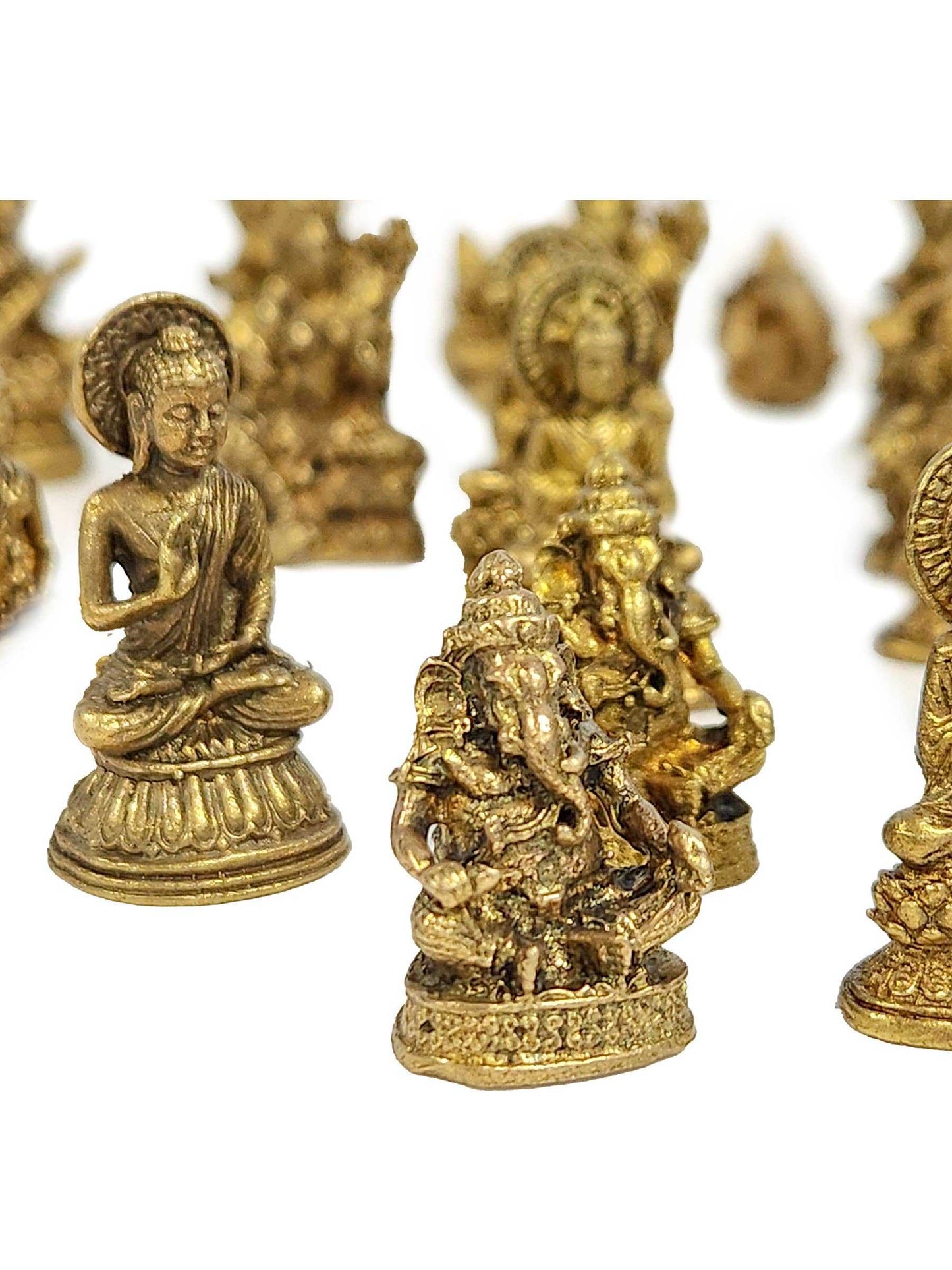 Small brass statue figurine sized to fit in the palm of a hand, shown in a styled setting