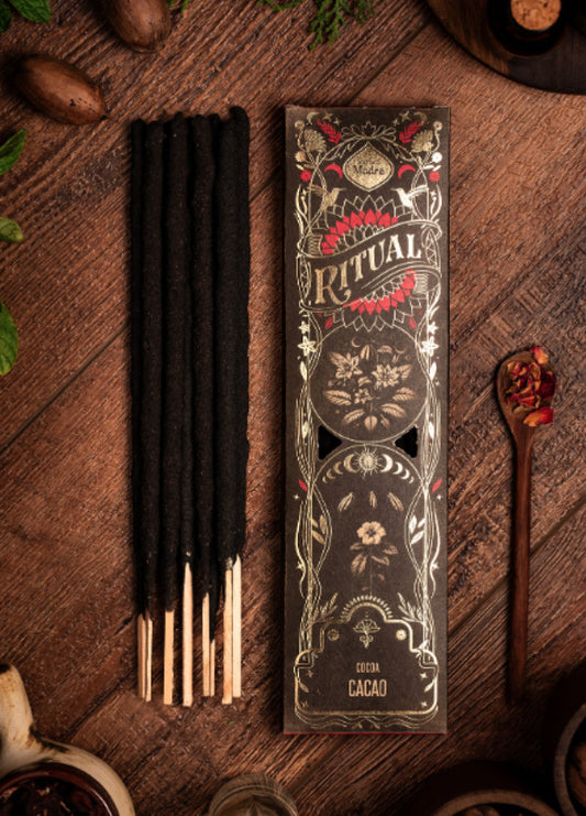 Cacao Ritual incense sticks beside the black and gold Ritual box on dark wood