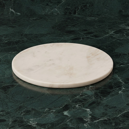 Round white marble platter on dark green marble
