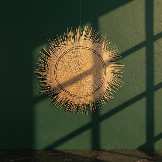 Sun Circle handwoven wall disc on a dark green wall in window light