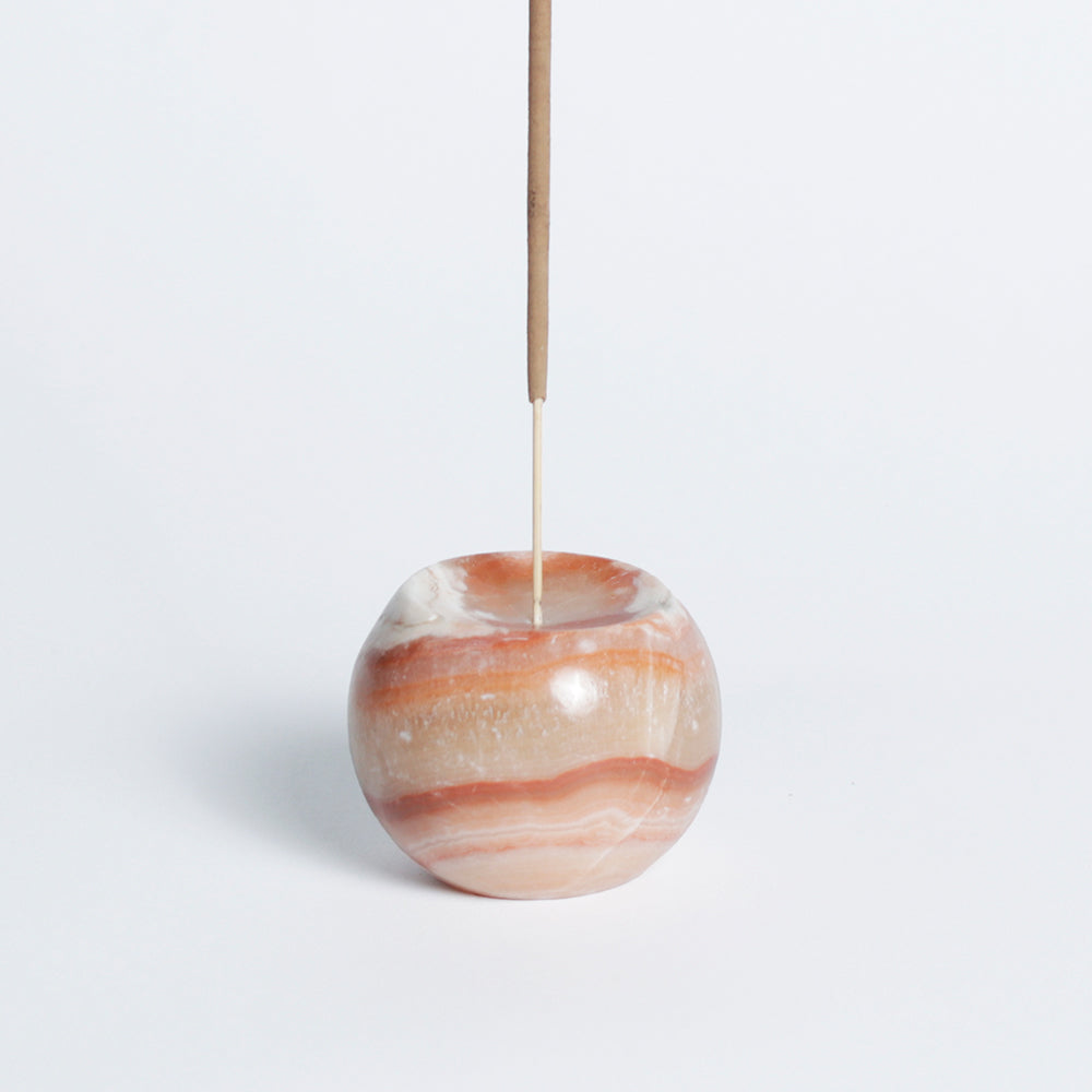 Banded cream onyx sphere incense holder holding a single upright incense stick
