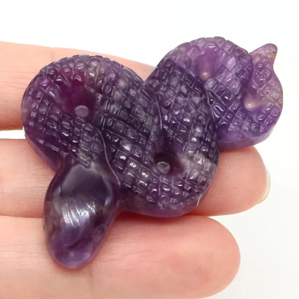 Carved gemstone snake figurine coiled on a dark surface — view 8 of 12