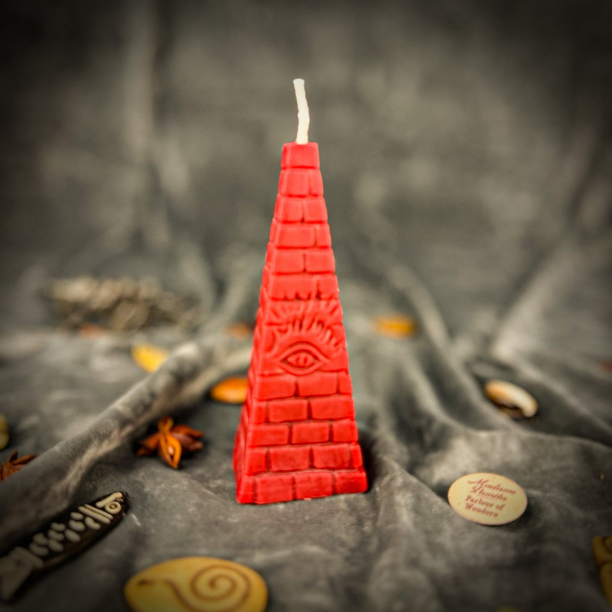Red pyramid candle, the eye and rays sharply molded above the base courses.