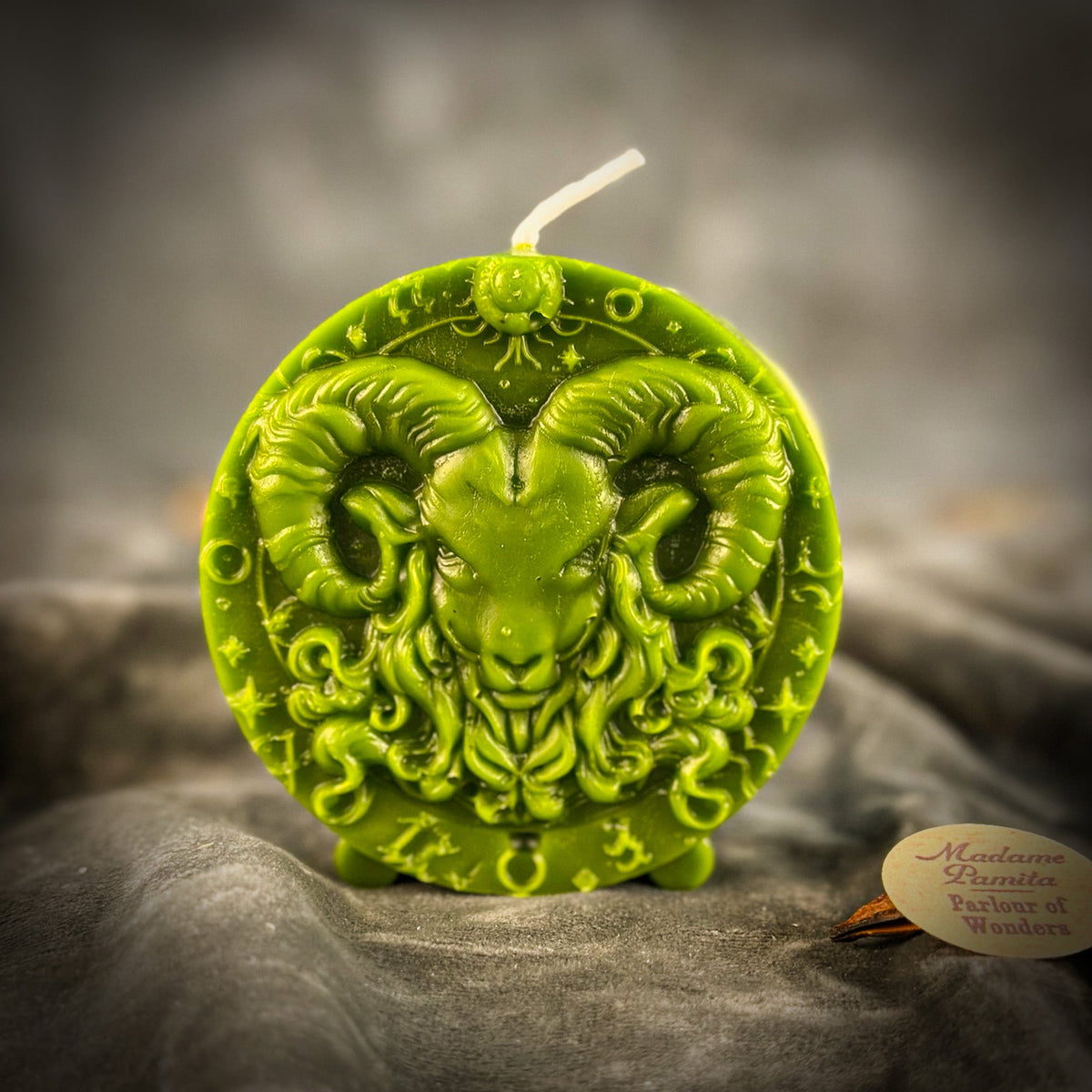 Olive-green Aries medallion candle, the border glyphs sharply raised.