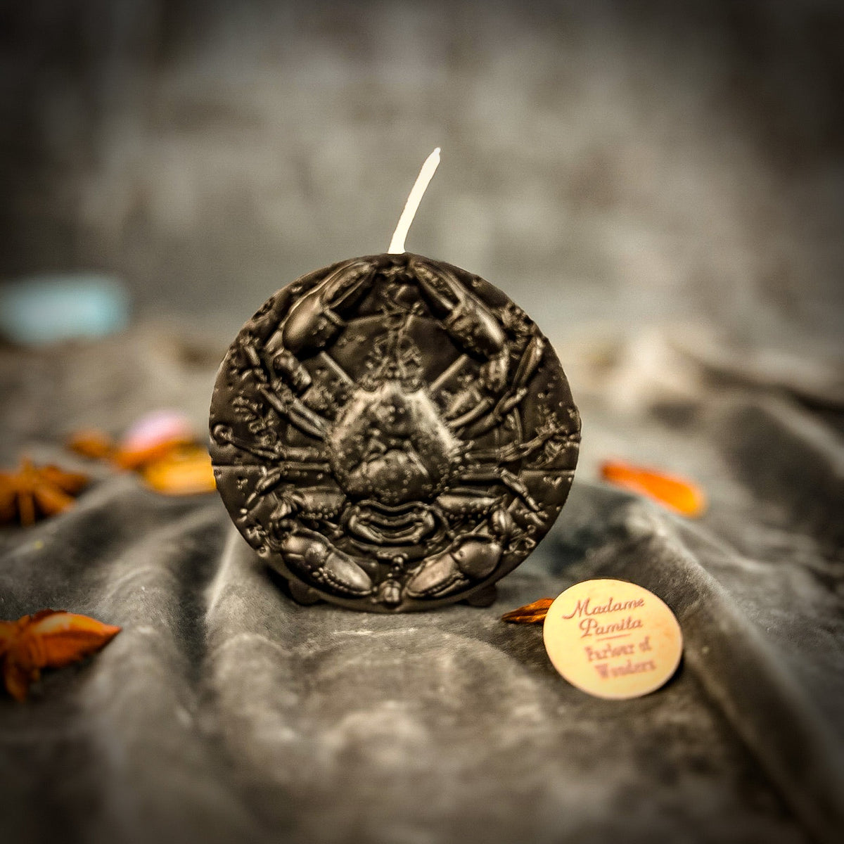 Cancer Crab zodiac spell candle in black on draped gray fabric