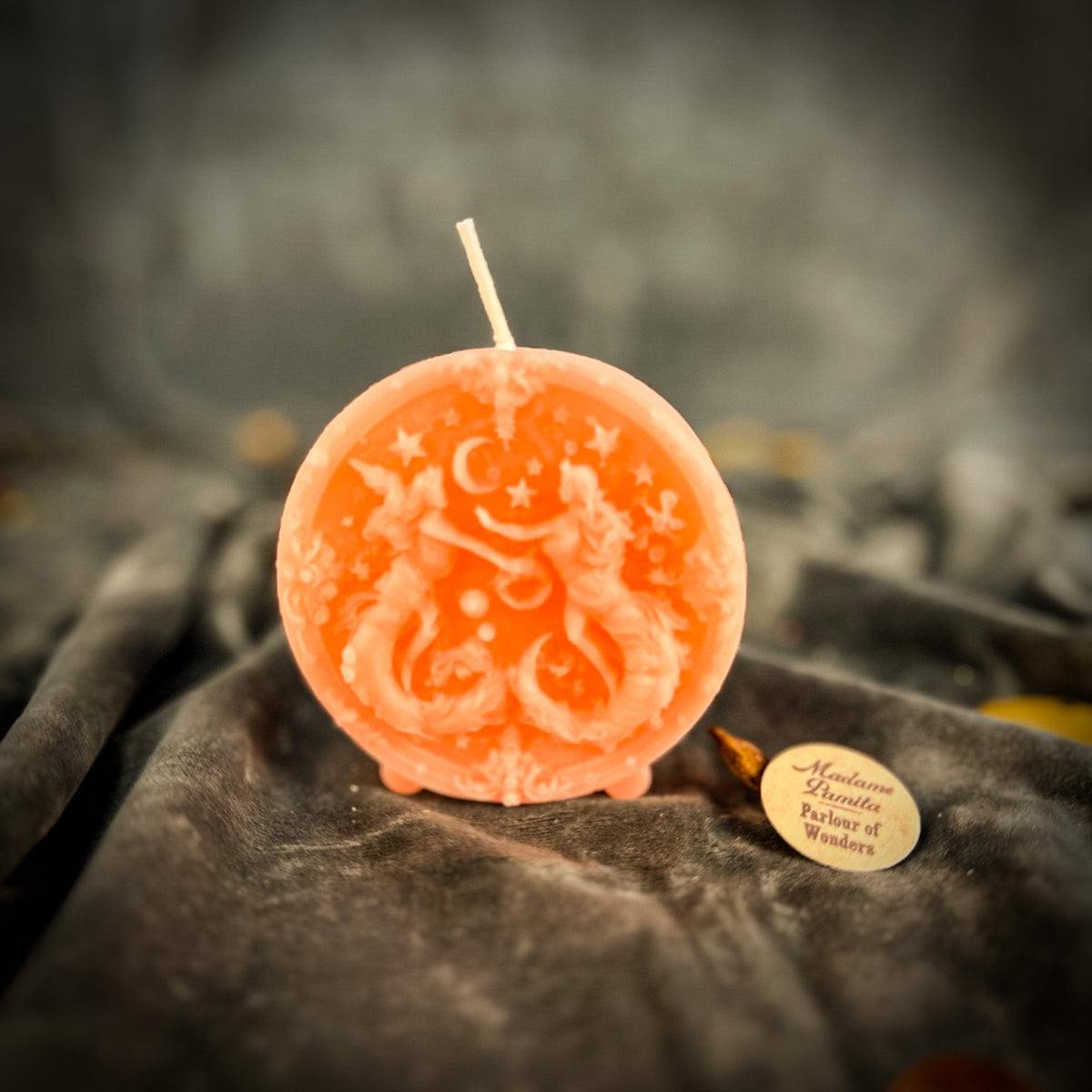 Peach Gemini medallion candle, the palest of the warm colors.