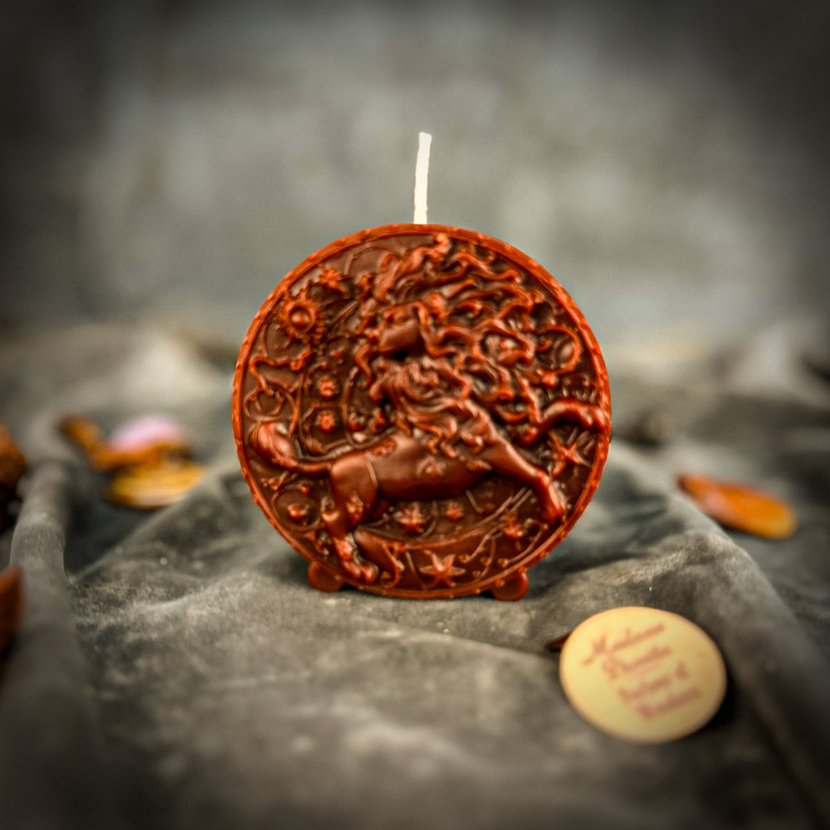 Leo Lion zodiac spell candle in brown on draped gray fabric