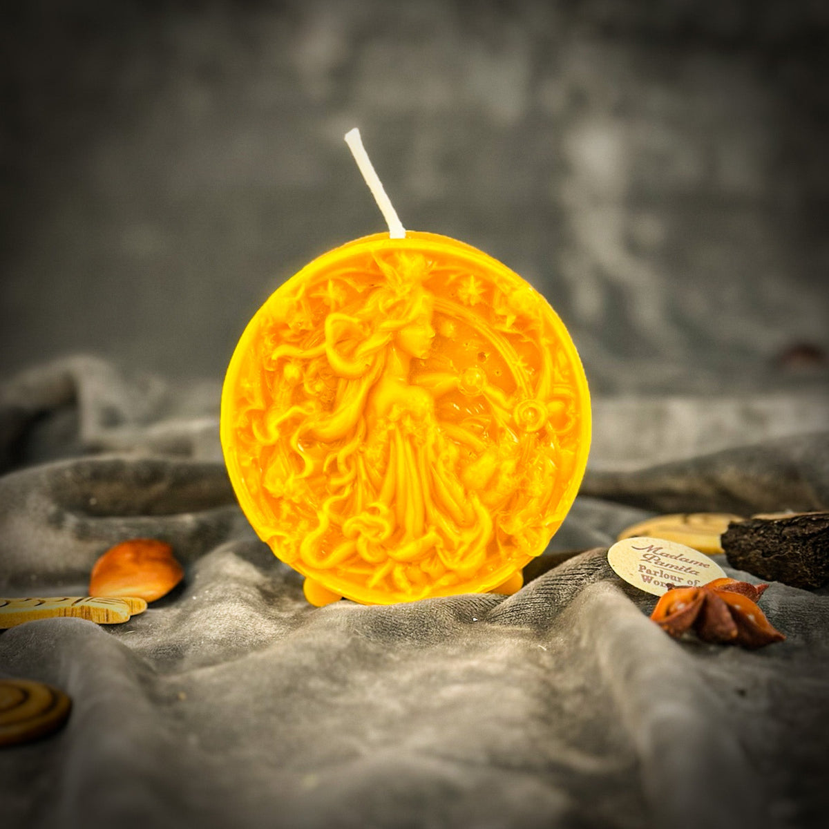 Libra Scales zodiac spell candle in yellow on draped gray fabric
