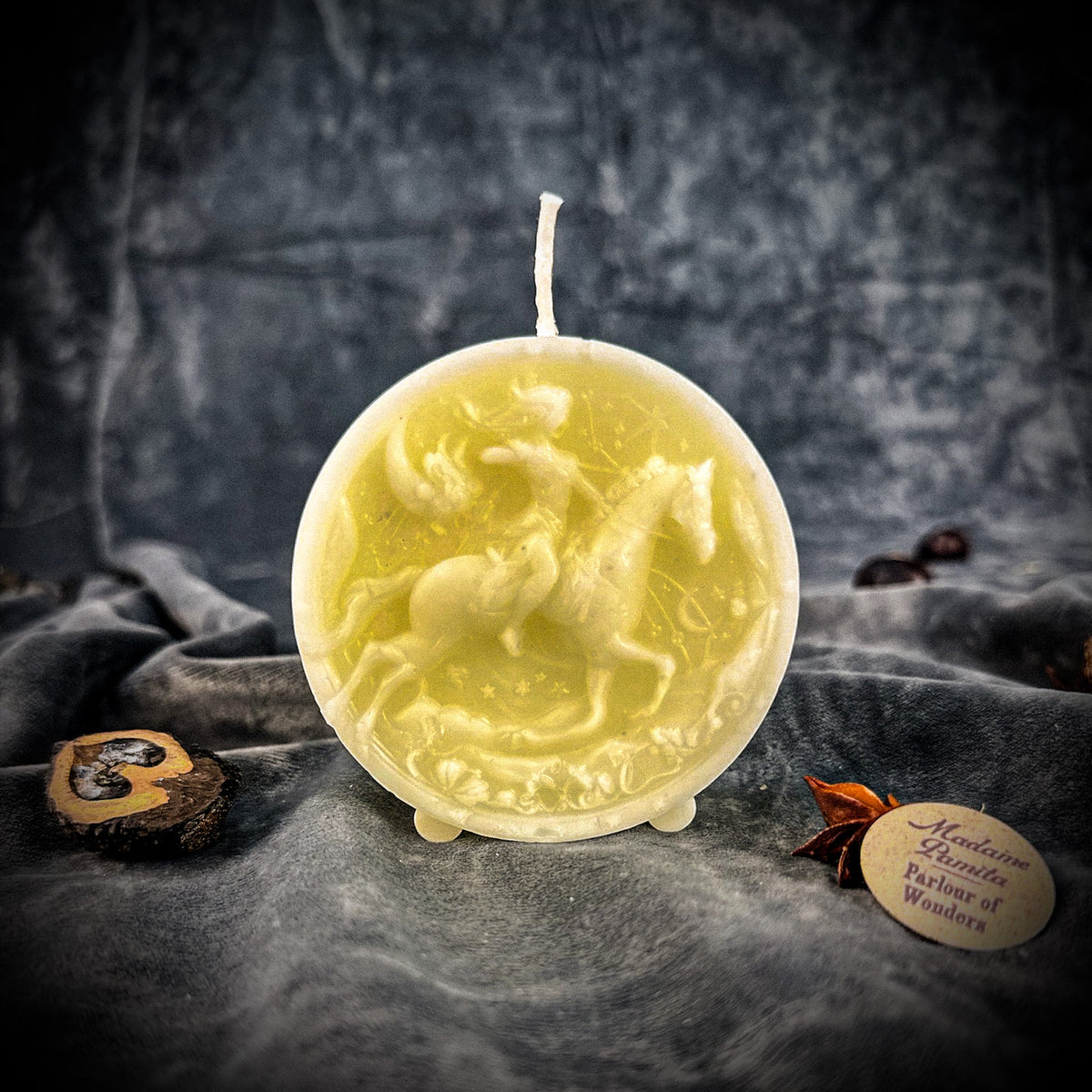 Sagittarius Archer zodiac spell candle in white on draped gray fabric