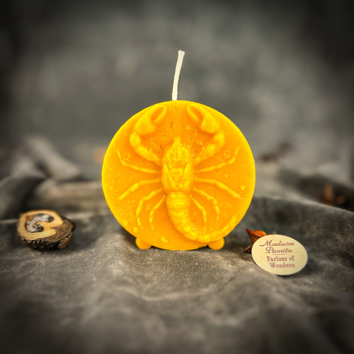 Amber-yellow Scorpio medallion candle, the most translucent of the range.