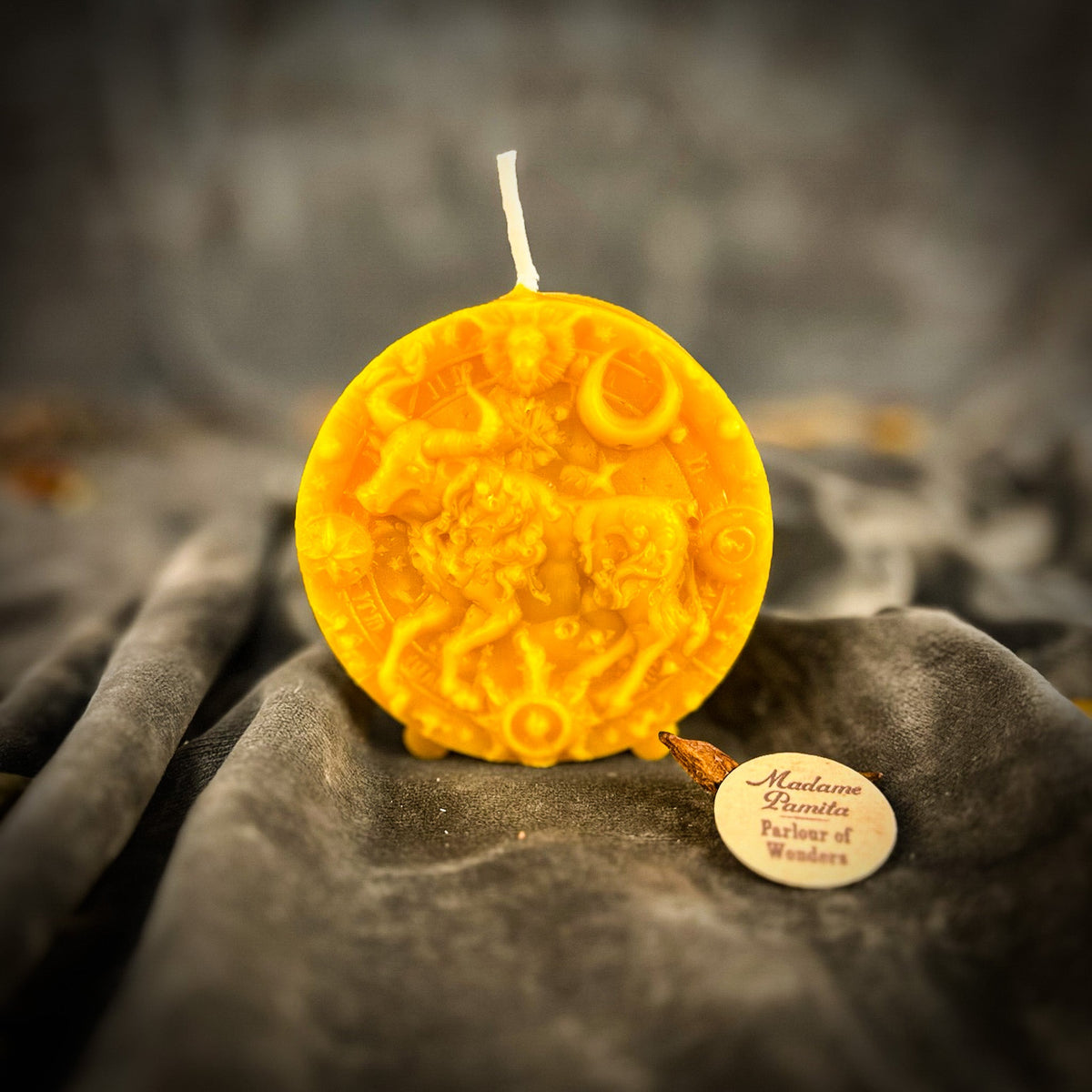 Taurus Bull zodiac spell candle in yellow on draped gray fabric