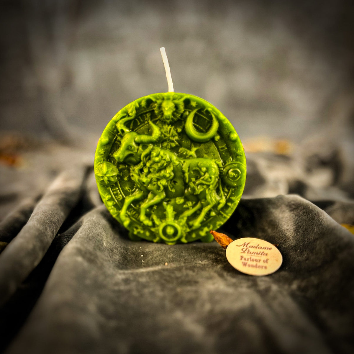 Taurus Bull zodiac spell candle in green on draped gray fabric