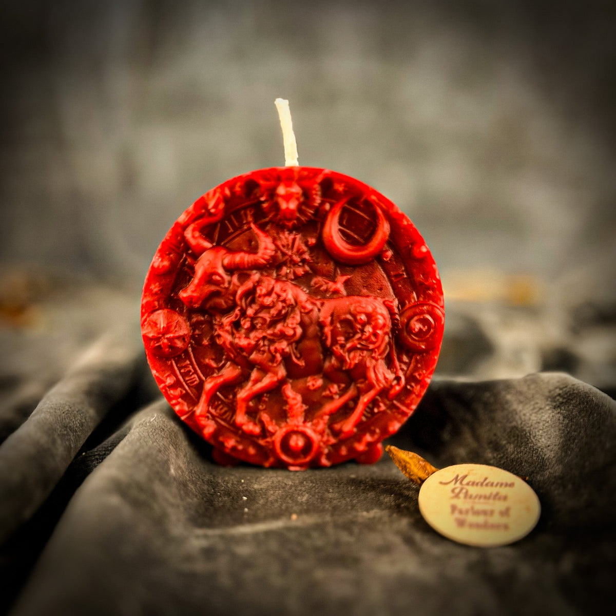 Taurus Bull zodiac spell candle in red on draped gray fabric