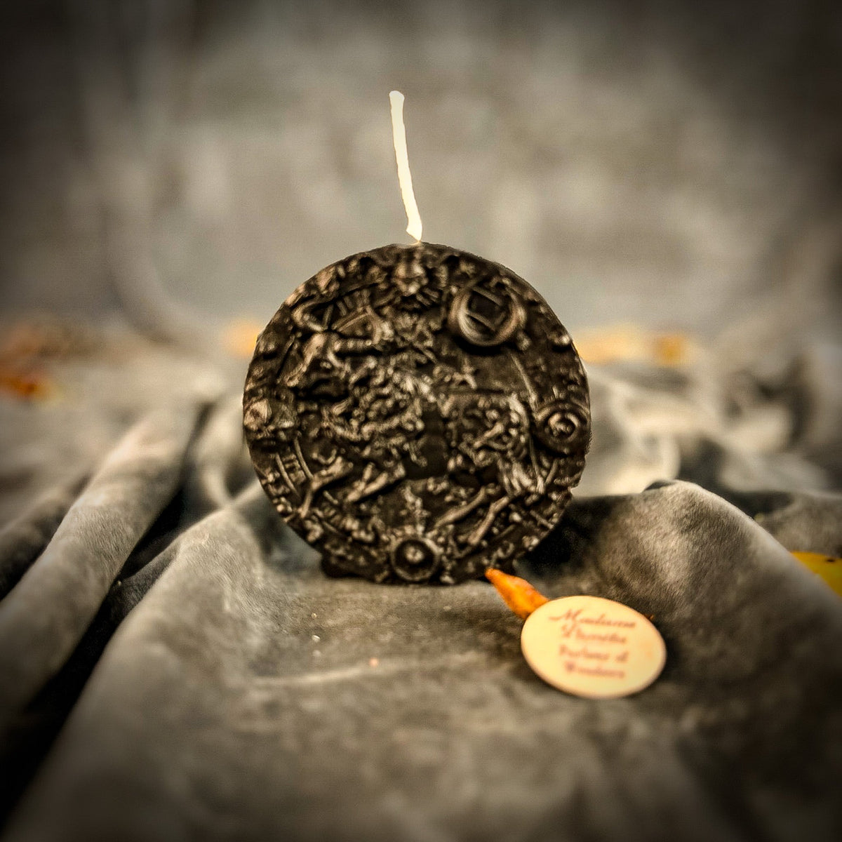 Taurus Bull zodiac spell candle in black on draped gray fabric