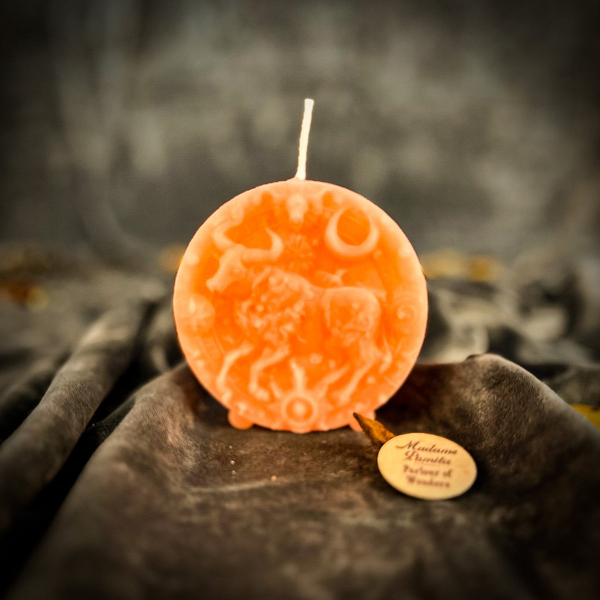 Taurus Bull zodiac spell candle in pink on draped gray fabric