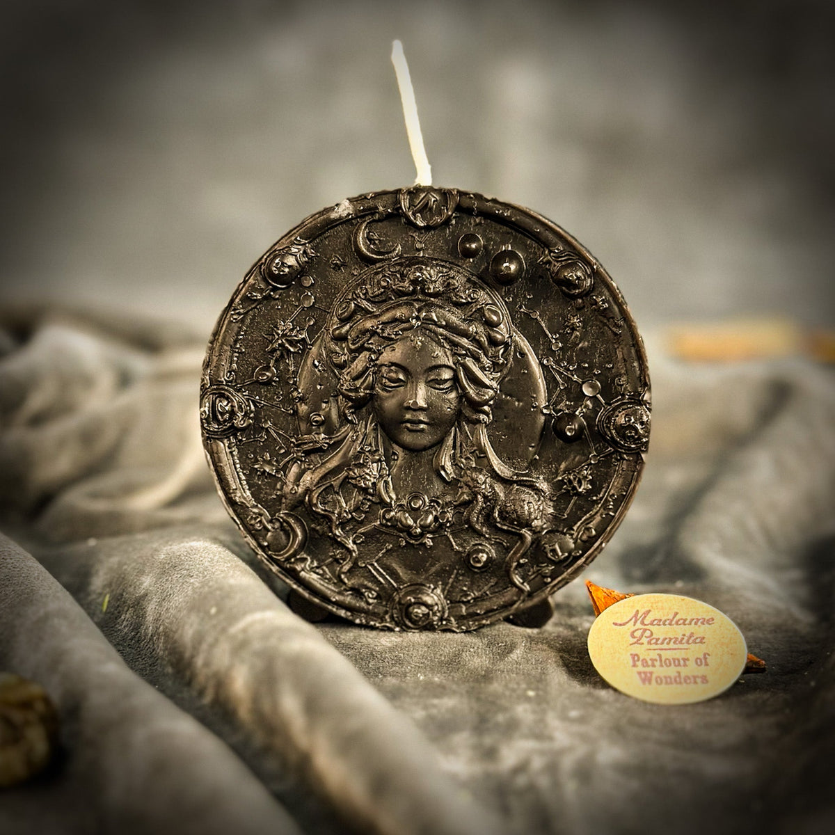 Black Virgo medallion candle, the Maiden readable only through highlights on the raised wax.
