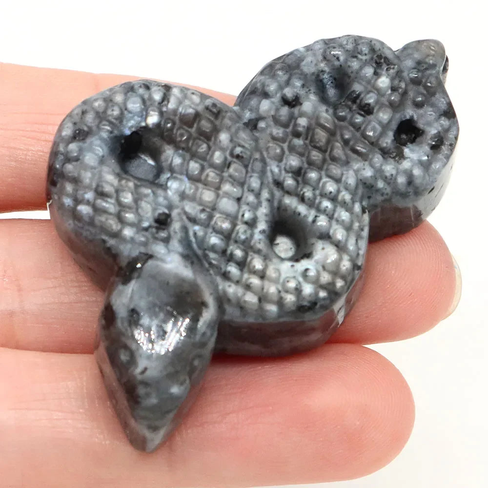 Carved gemstone snake figurine coiled on a dark surface — view 10 of 12