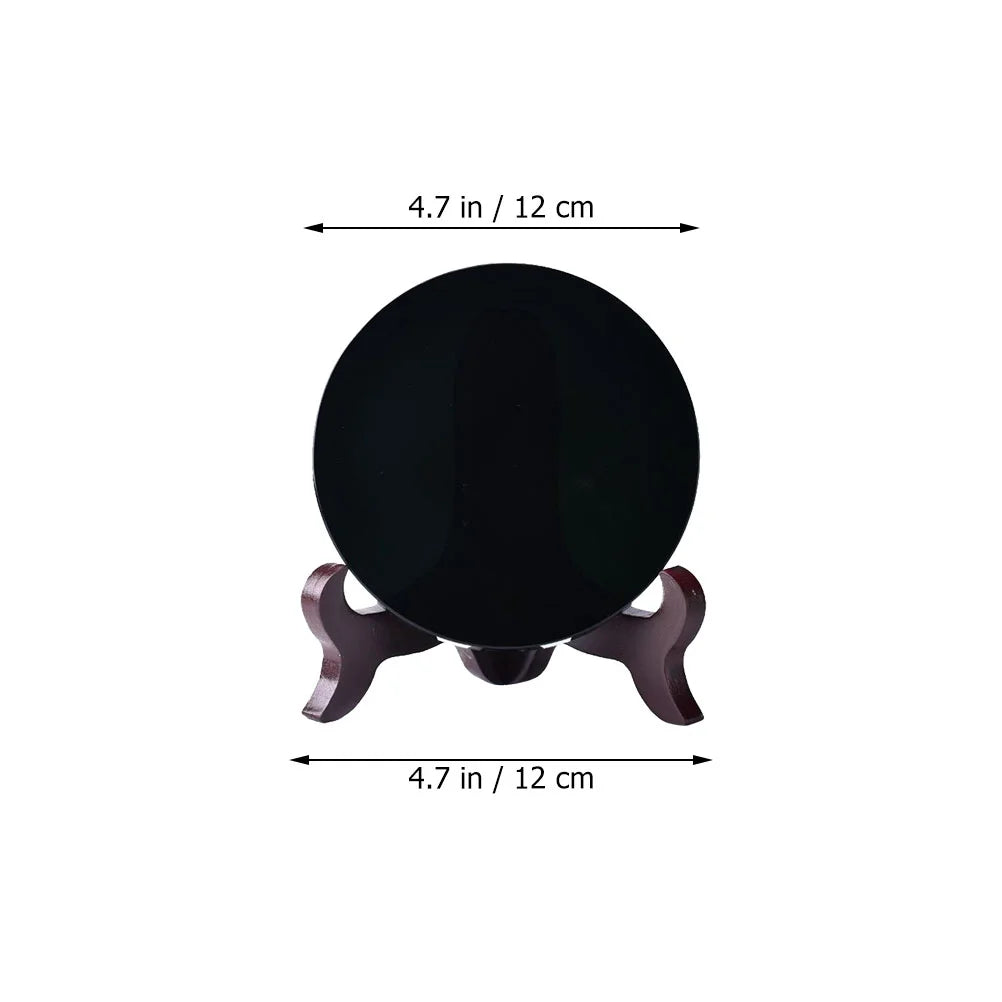 Round polished black obsidian scrying mirror resting on its base stand — view 5 of 11